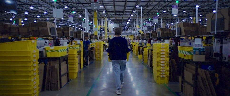 A worker walking a fulfilment centre aisle
