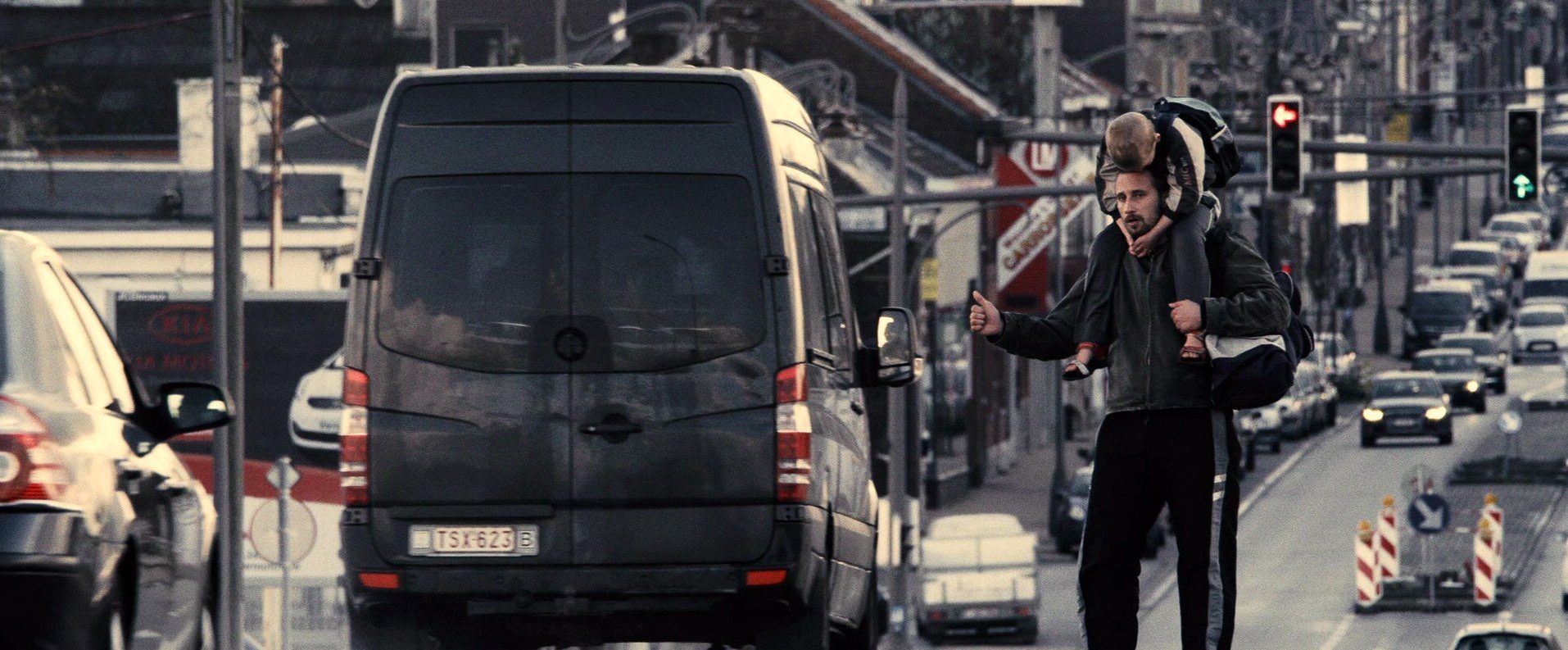 Raul carrying his son on his shoulders through traffic