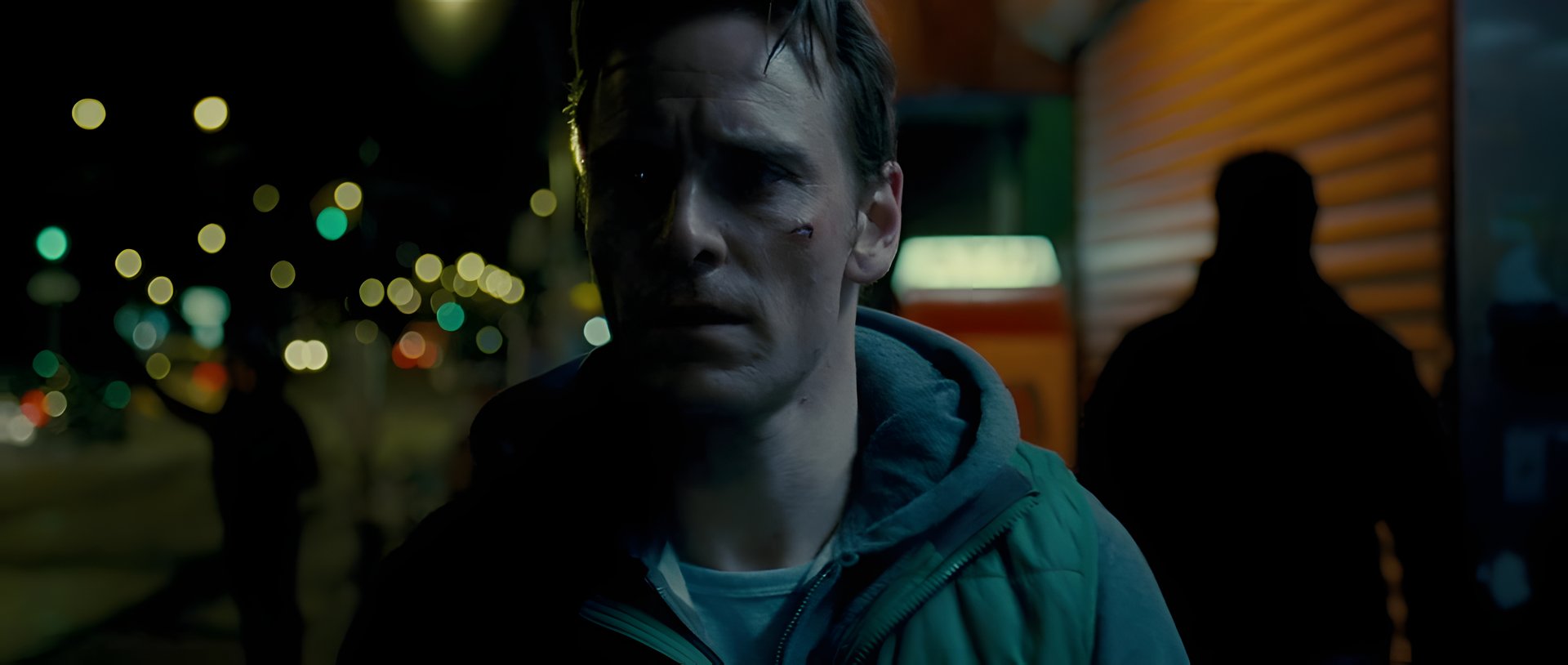 Raul, bruised, on a city street at night