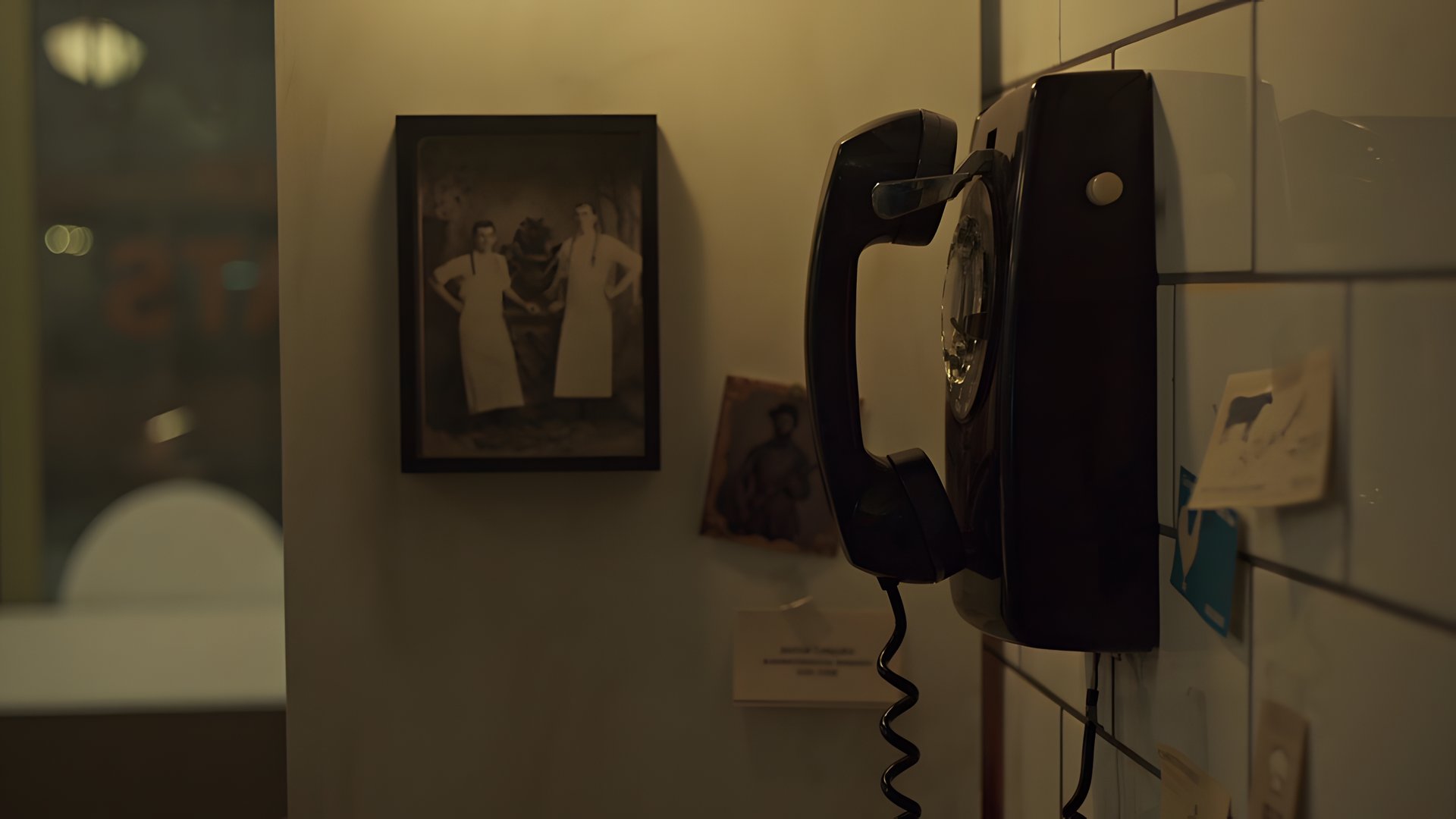 A wall telephone, handset off the hook