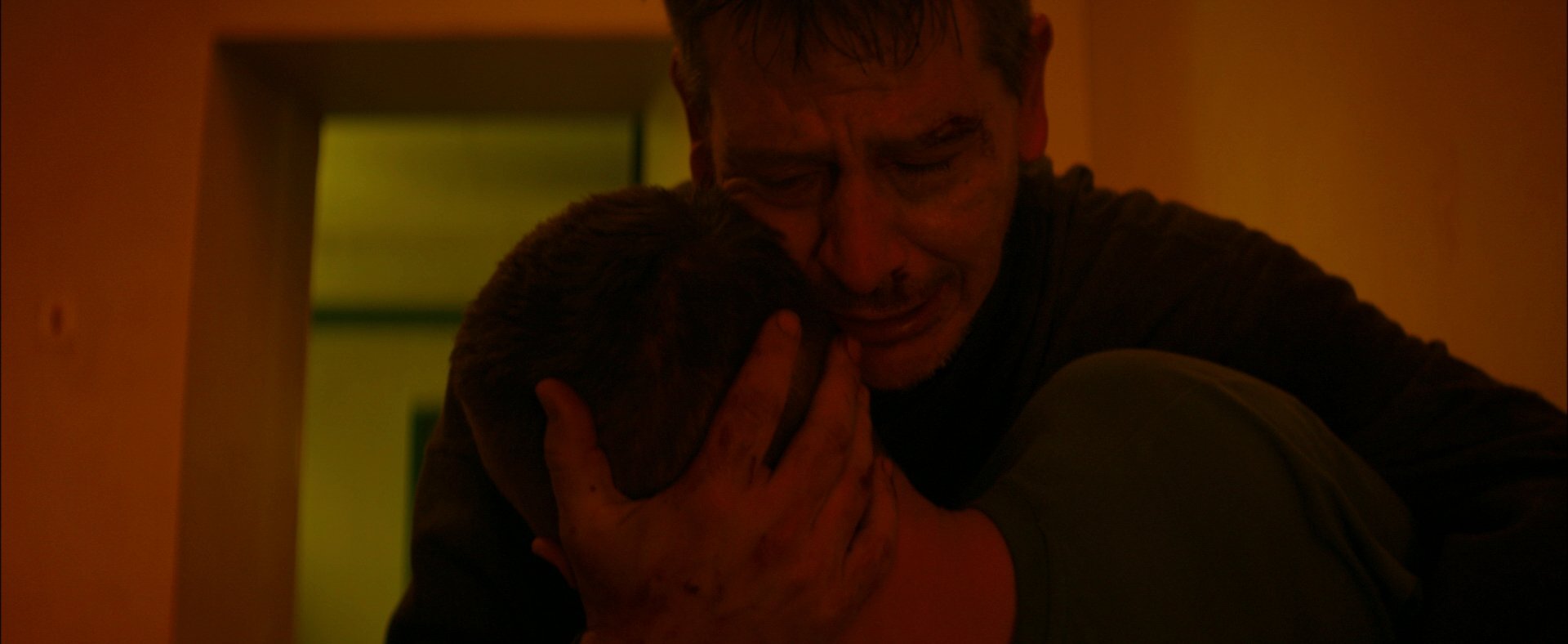 Raul holding someone close in a doorway