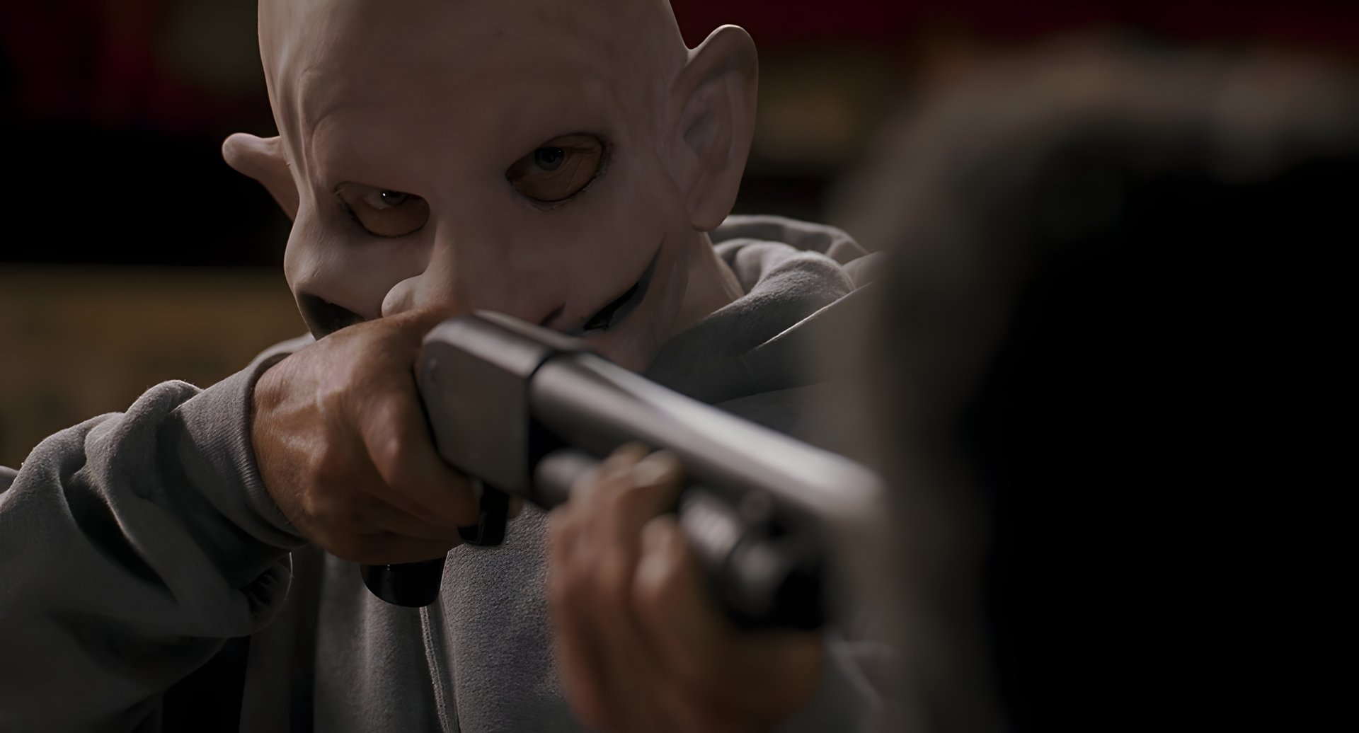 A masked man levelling a shotgun
