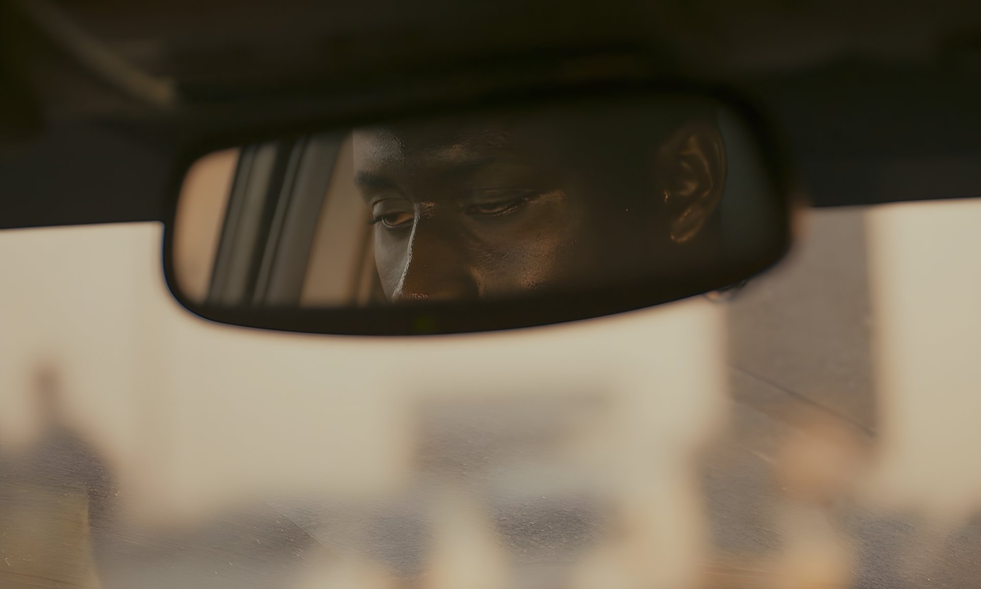 Tired eyes reflected in a rear-view mirror
