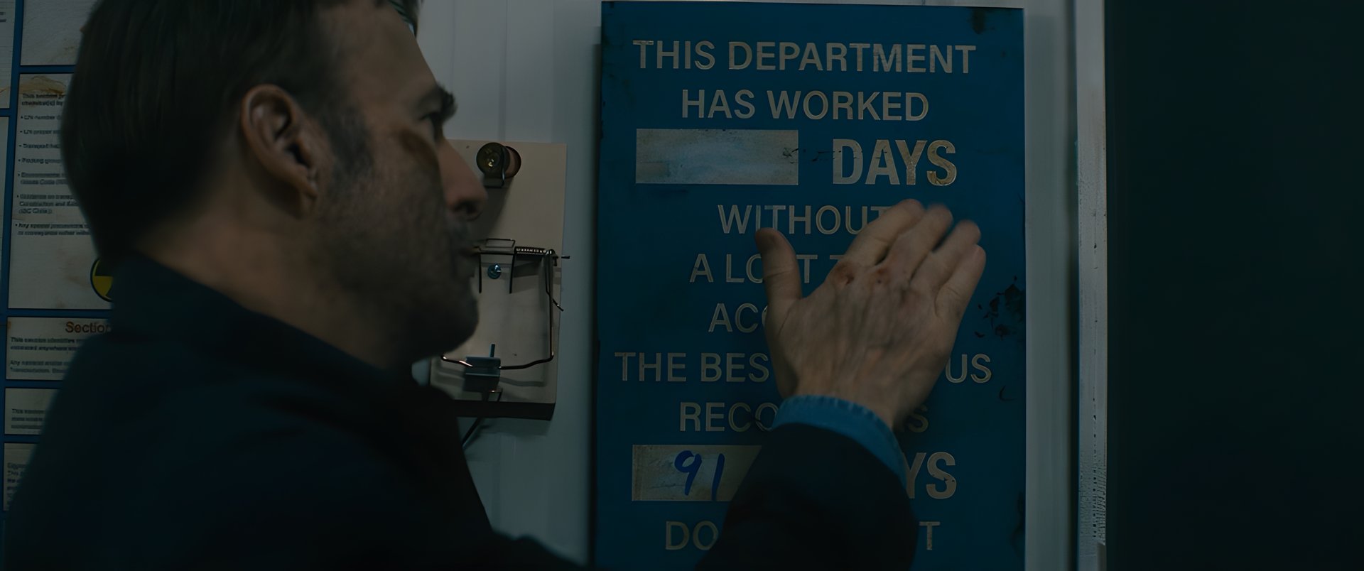 A worker beside a days-without-incident sign